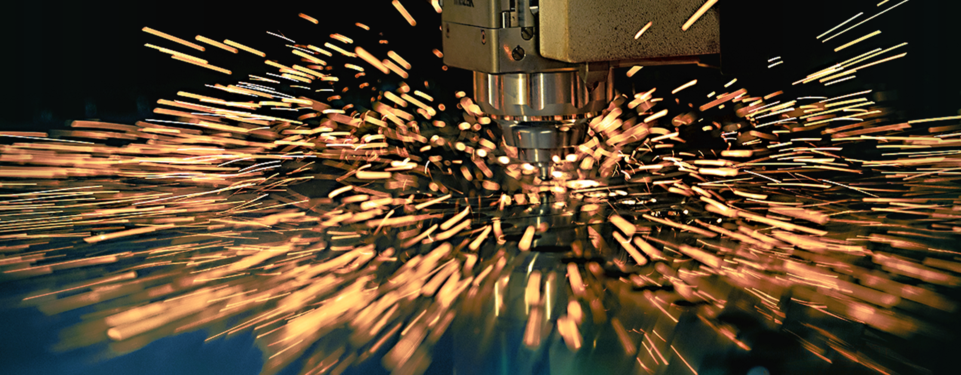 Industrial CNC (Computer Numerical Control) Laser Cutting Machine in Greenville, Wisconsin Industrial CNC fiber laser cutting machine cutting sheet metal with sparks at Midwest Sheet Metal & Fabrication in Greenville, Wisconsin.